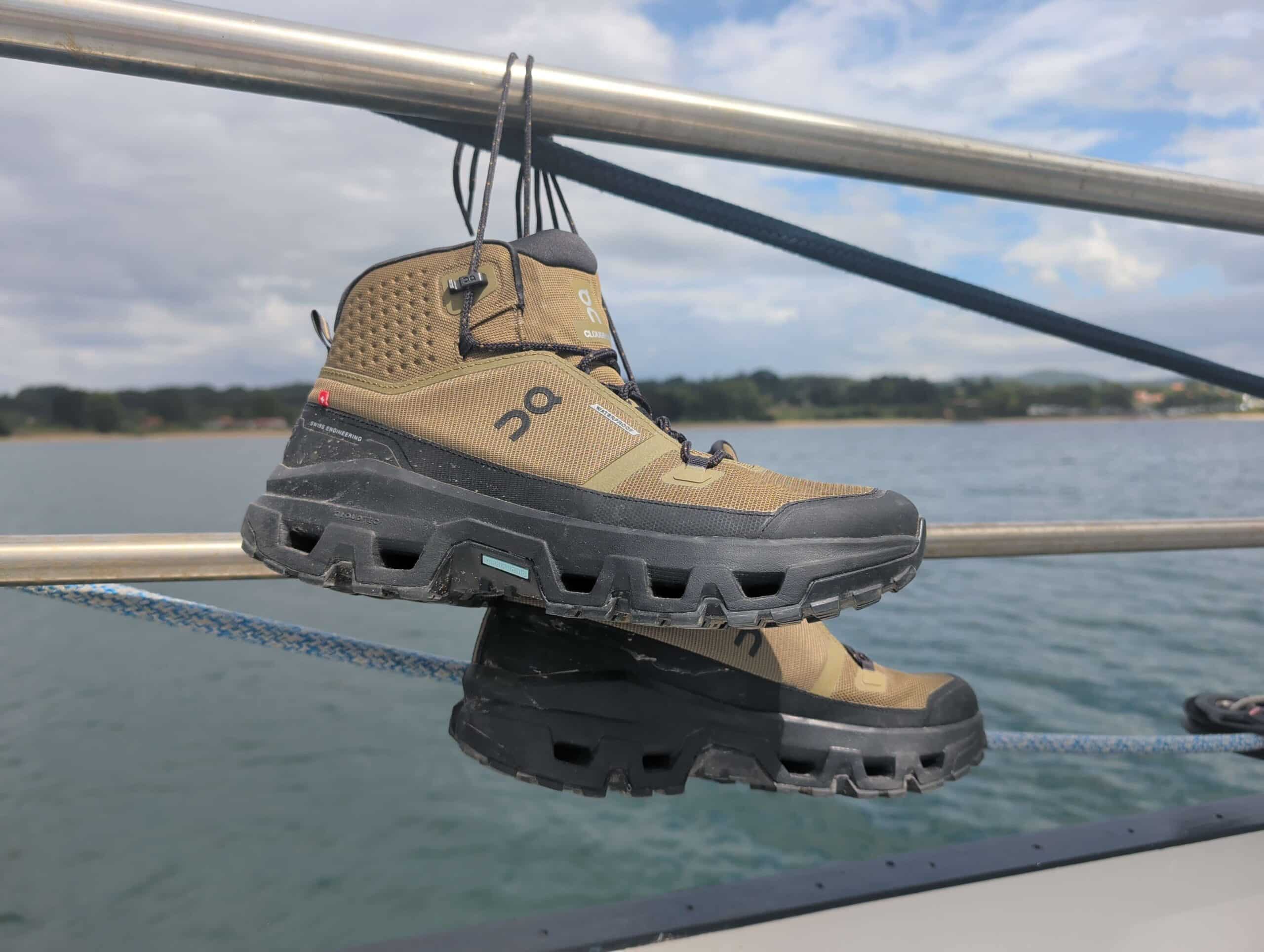 wandelschoenen hangend aan de reling van een zeilschip